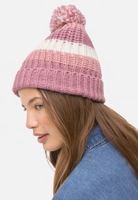 Gorro de punto con rayas alternas en rosa y blanco, rematado con un pompón rosa y una textura acanalada para un ajuste ceñido.
