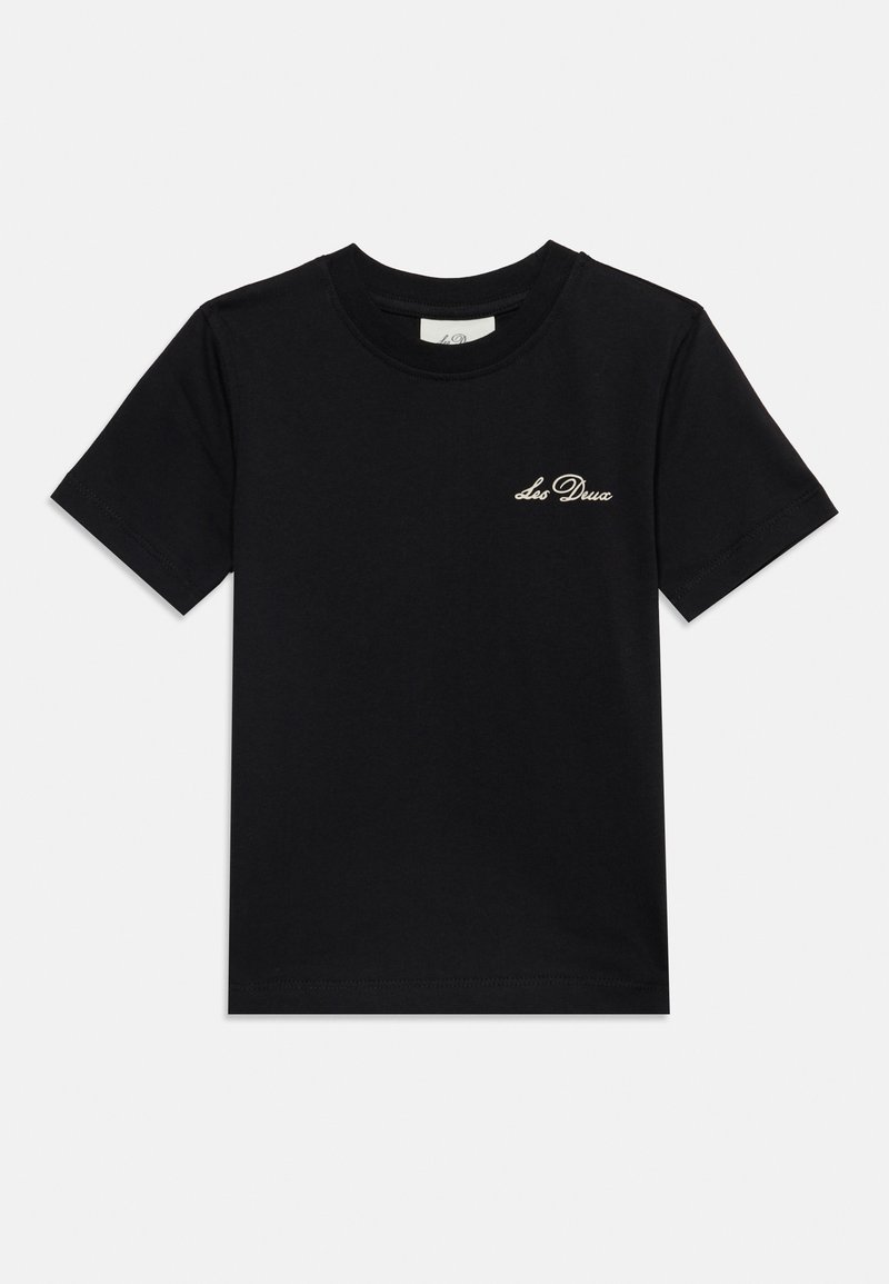 Μαύρο κοντομάνικο t-shirt με μικρό λευκό καλλιγραφικό λογότυπο "Les Deux" στην αριστερή πλευρά του στήθους πάνω σε jednobarve υπόβαθρο.