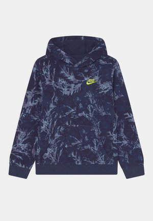 Granatowa bluza z kapturem z jasnoniebieskim abstrakcyjnym wzorem liści i neonowożółtym logo Nike na piersi, wyposażona w przednią kieszeń kangurka.