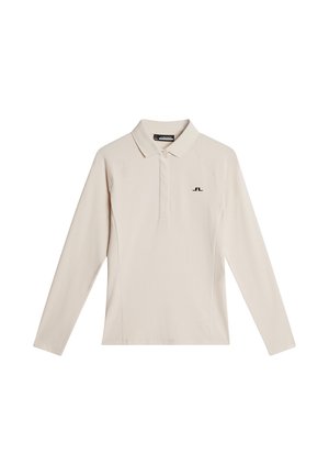 Beige långärmad polo skjorta med krage, med en svart logo på vänster bröst, tillverkad av ett glatt och lätt tyg.