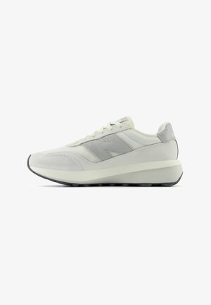 Weiße Sneaker mit grauen Akzenten, ausgestattet mit einem strukturierten Mesh-Obermaterial, flachen Schnürsenkeln und einer leicht erhöhten Gummisohle für besseren Halt.