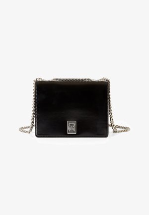 Petite pochette rectangulaire noire brillante avec une chaîne argentée comme bandoulière et un petit fermoir décoratif argenté à l'avant, sur fond blanc.