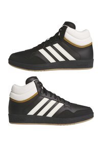 Höga sneakers i svart läder med vita ränder, guldaccent och gummisula; har vadderad krage och snörning fram.