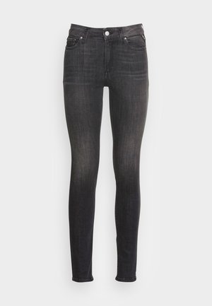 Dunkle Jeans im Skinny-Schnitt mit hoher Taille, Fronttaschen und dezentem Verblassen. Der Stoff hat eine glatte Textur und robuste Nähte.