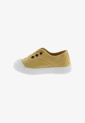 Zapato deslizable amarillo de lona con puntera de goma blanca y suela texturizada, que presenta dos ojales a cada lado para ventilación.