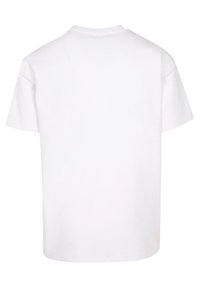 Fehér pamut póló, rövid ujjú, kerek nyakkivágással. Simma textúra, laza fazon, nincs látható minta vagy díszítés. Hátsó nézet látható.