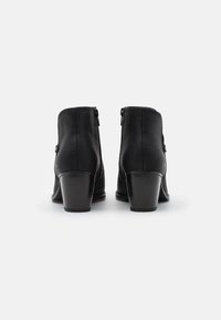 Bottes de cheville en cuir noir avec un dessus texturé, fermetures éclair à l'arrière et talons empilés. Fini lisse avec un design à bout rond.