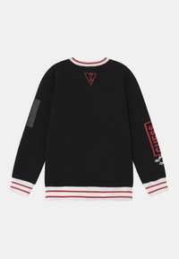 Musta collegepaita, jossa on punavalkoraidalliset resorit hihoissa ja kauluksessa. Selässä punainen logo ja hihassa harmaa koriste.