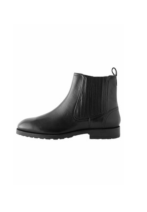 Botas negras de cuero hasta el tobillo con paneles laterales elásticos, punta redondeada y acentos texturizados. Cuenta con una lengüeta y una suela plana de goma.