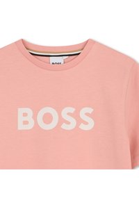 Φωτεινό ροζ βαμβακερό μπλουζάκι με στρογγυλή λαιμόκοψη και μεγάλο λευκό λογότυπο "BOSS" στο στήθος. Απαλή υφή και κοντά μανίκια.