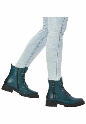 Bottines en cuir vert sarcelle avec des lacets noirs, une fermeture éclair sur le côté et une semelle en caoutchouc. Détails encouture et une boucle décorative au niveau de la cheville.