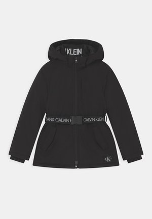 Czarna kurtka z kapturem zapinana na przedni zamek, regulowany pasek z logo Calvin Klein, boczne kieszenie oraz naszywka z logo na dolnym obszyciu.