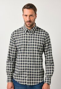 Camicia a quadri nei colori beige, blu navy e bianco. Caratterizzata da colletto a bottone, maniche lunghe e orlo arrotondato. Realizzata in tessuto a trama.