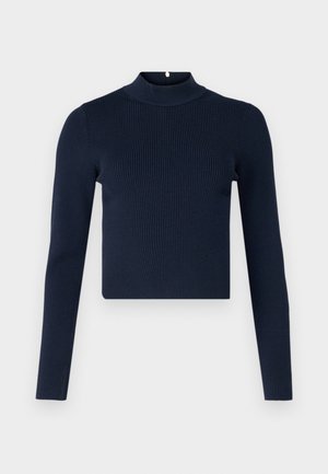 Haut à manches longues côtelé bleu marine avec un col montant et un design cropped. Fabriqué en tissu texturé avec un style minimaliste.
