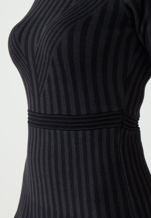 Abito nero in maglia con righe verticali, silhouette aderente, tessuto strutturato e costine orizzontali in vita per un tocco di dettaglio.