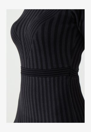 Robe en tricot noir avec des rayures verticales, silhouette ajustée, tissu texturé et côtes horizontales à la taille pour une touche de détail.