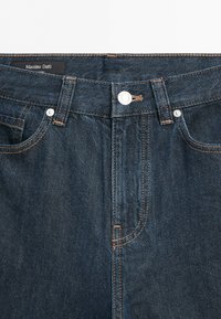 Dunkelblaue Jeans aus Denim mit oranger Naht, Knopfverschluss vorne, Gürtelschlaufen und einem sichtbaren Massimo Dutti-Label im Bund innen.