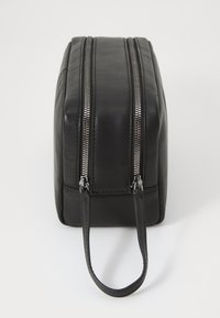 Beauty case in pelle nera con due cerniere argento, forma rettangolare, manico laterale e texture liscia. Adatto per viaggi o per riporre oggetti.