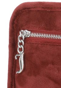 Sacca in suede rosso con una cerniera argento e una decorativa catena con un tirante accentuato dalla lettera stilizzata "J."