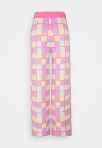 Stickade byxor med vida ben och ett rosa elastiskt midjeband. Har ett pastell-rutigt mönster i rosa, gult och vitt. Mjuk textured tyg.