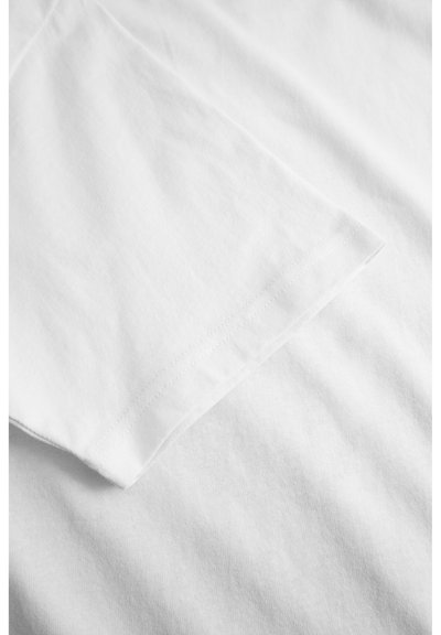 Tricou alb din bumbac, cu guler rotund, mâneci scurte și o textură curată, netedă. Are un tiv cusut pe marginea mânecilor.