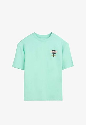 T-shirt vert menthe à manches courtes avec un petit graphisme et le texte "TEDDY SMITH" sur le côté gauche de la poitrine.