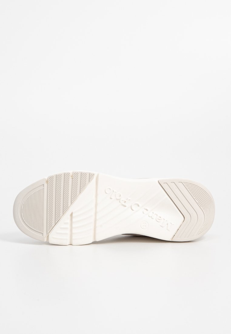 Weiße Gummisneaker-Sohle mit strukturierten Mustern, kantigen Linien und einem auf der Seite eingestempelten Logo. Glatte Oberfläche mit erhöhten Profilbereichen.