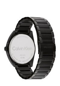 Orologio in acciaio inossidabile nero con una finitura opaca e slanciata, dotato di una cassa rotonda e di un bracciale a maglie coordinato. Logo impresso sul retro. Impermeabile.