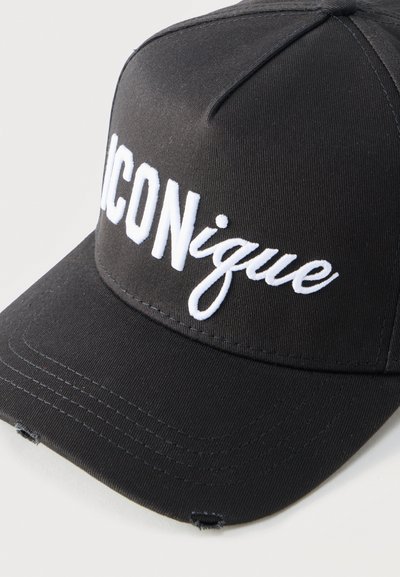 Μαύρο καπέλο μπέιζμπολ με λευκό κεντημένο κείμενο "ICONique" και μικρές φθαρμένες τρύπες στη γείσο, εμφανίζεται σε απλό λευκό φόντο.