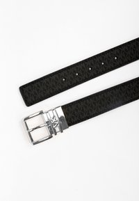 Zwarte riem met een textuurpatroon, zilveren metalen gesp en meerdere verstelbare gaten. Plat ontwerp, gemaakt van synthetisch materiaal.