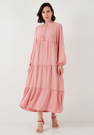 Pink, long-sleeve dress with a high neckline, tie detail, and tiered design. Soft fabric, gathered sleeves, and a flowing silhouette.
