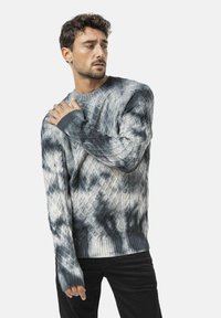 Strickpullover in Grautönen mit einem Rautenmuster, gerippten Bündchen und Saum. Verfügt über eine lockere Passform und eine strukturierte Oberfläche.