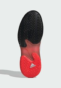 Schwarze und rote sportive Schuhsohle mit einem Zickzack-Profil, ausgestattet mit einer durchsichtigen roten Zwischensohle und einem weißen Adidas-Logo.