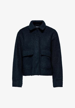 Veste cropped en bleu marine foncé en tissu texturé, avec un col et deux grandes poches avant. Surface douce et légèrement duveteuse.