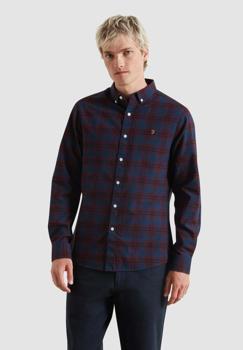 Camicetta a maniche lunghe blu scuro con motivo a quadri rossi, colletto button-down e bottoni bianchi. Presenta un piccolo logo ricamato sul lato sinistro del petto.