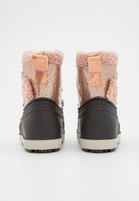 Botines de tobillo en color rosa y con purpurina metálica, forrados con piel sintética, suelas de goma negra y herrajes decorativos en la parte posterior. Incluye acentos texturizados.