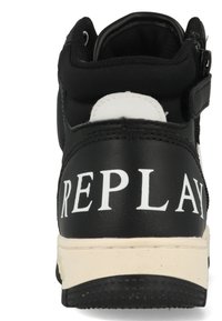 Zwarte hoge sneaker met een wit logo op de hiel, gemaakt van glad synthetisch materiaal, en een contrasterende beige zool. Voorzien van een klittenbandsluiting.