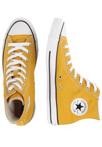 Gula canvas högtoppsneakers med vita snören, svarta detaljer och en cirkulär logopatch. Gummitåhätta och texturerad sula.