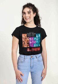 Camiseta de algodón negra con un gráfico de la "Tabla Periódica de Cuentos de Hadas" con cuadrados coloridos que representan varios personajes. Mangas cortas, cuello redondo.