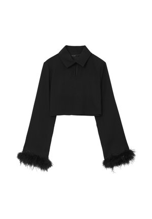 Haut noir à manches longues, court, avec un col, présentant des accents de plumes noires duveteuses aux poignets et une petite ouverture en forme de clef au niveau du décolleté.