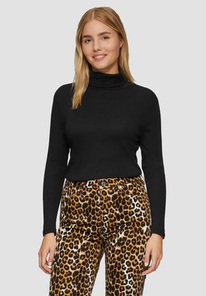 Zwarte coltrui met lange mouwen, gecombineerd met broek met een bruin en zwart luipaardpatroon, voorzien van een gladde textuur en voorzakken.