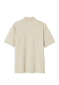 Polo beige à manches courtes avec une texture côtelée, un col plat et des manches à revers. Présente une coupe droite et un tissu doux et léger.