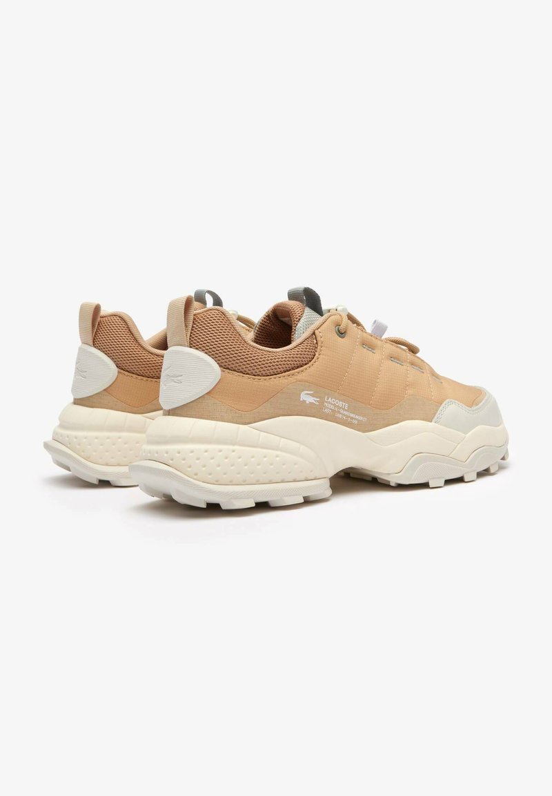 Beżowe siateczkowe i tekstylne sneakersy z białą gumową podeszwą. Posiadają wyściełany kołnierz, sznurowane zapięcie oraz wytłoczone logo marki na pięcie.