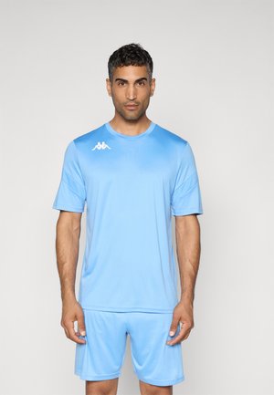 Maillot de sport bleu clair avec manches courtes, col rond, texture lisse, présentant un logo blanc sur la poitrine gauche et un short assorti.