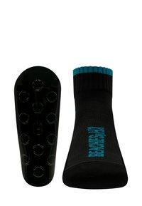 Schwarze Socke mit türkisfarbenen Akzenten, ausgestattet mit einem gerippten Textur und einer rutschfesten schwarzen Sohle mit Grip-Punkten. Akzentuiert mit dem Wort "BRAND" in Türkis.