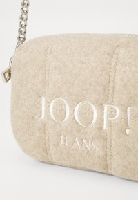 Borsa a tracolla in feltro beige con design trapuntato. Caratterizzata da logo ricamato "JOOP!" e tracolla in catena argentata. Texture morbida con cuciture visibili.