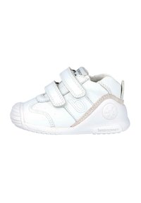 Zapatillas de deporte blancas para niños con dos tiras de Velcro ajustables, punta redondeada, suela de goma texturizada y un logo sutil en el lateral.