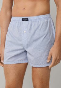 Ljust blå boxershorts med ett fint, upprepande mönster. Resårmidja och en knappdetalj fram. Varumärkesetikett: Hackett London.