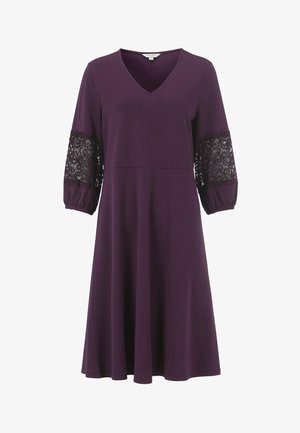 Lila V-Ausschnitt Kleid mit Dreiviertelärmeln, das schwarze Spitze an den Ärmeln und eine fließende Silhouette aufweist. Hergestellt aus weichem Stoff.