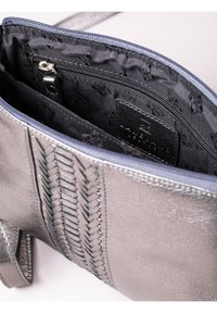 Leather handbag in metallic gray with woven design accents, featuring a black-lined interior and a zippered compartment for organization.